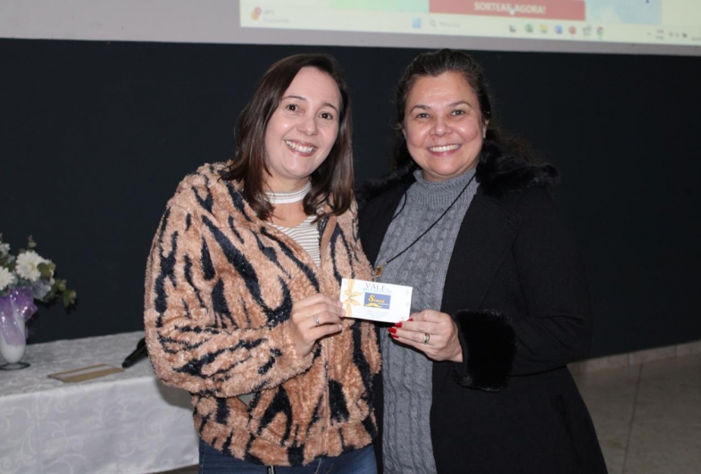 Professora Perla recebendo o prêmio do sorteio realizado aos participantes