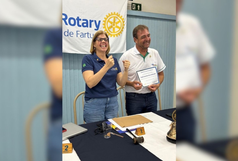 Presidente Daniela Viana  entrega um certificado de  agradecimento a Luiz