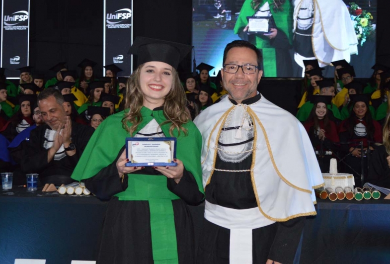 Reitor Dr. Alexandre Chaddad premiando a melhor aluna da turma de biomedicina, Beatriz Zanella Agostini de Oliveira