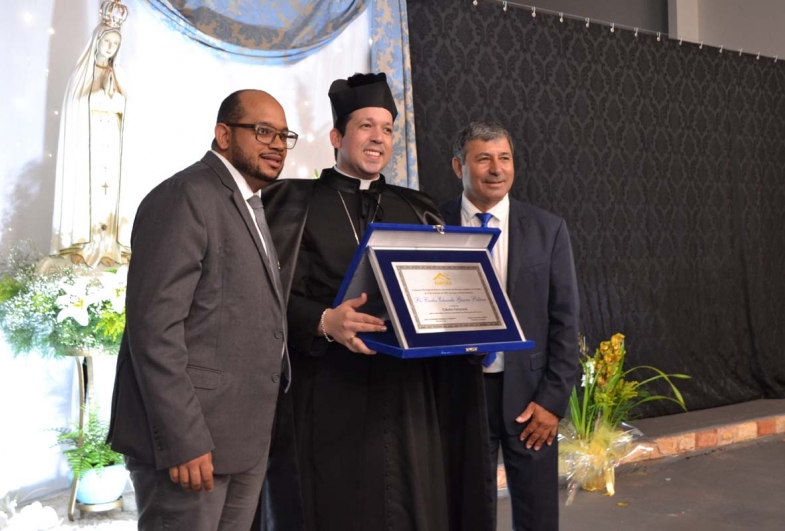 Juliano Damasio e João Buranello entregando o título de  cidadão farturense ao padre Carlos