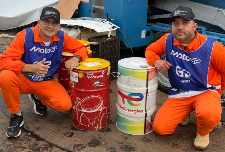 Luiz e Marcos ao lado dos galões do  combustível oficial do MotoGP