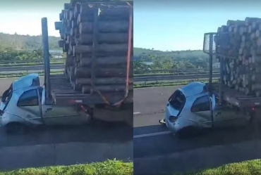 Carro fica preso embaixo de caminhão carregado com  madeira após batida em  rodovia em Itapeva